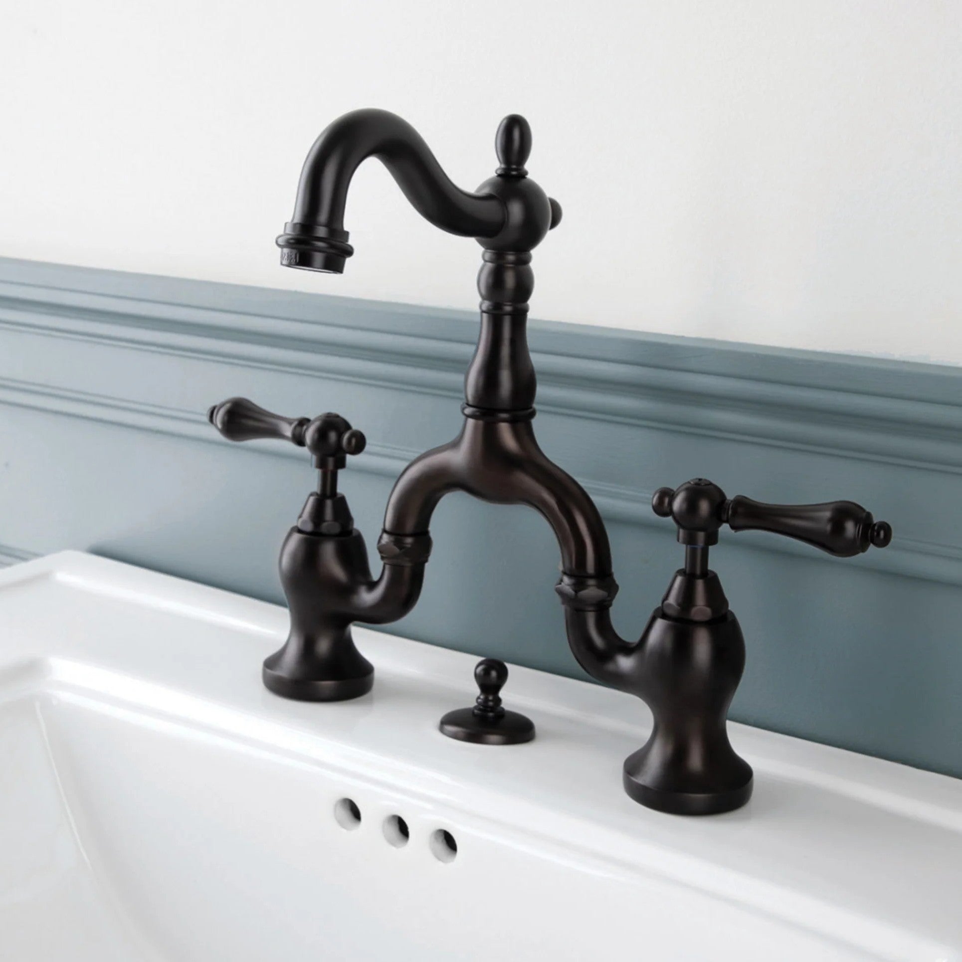 Vintage-style black faucet on a white sink with a light blue wall background