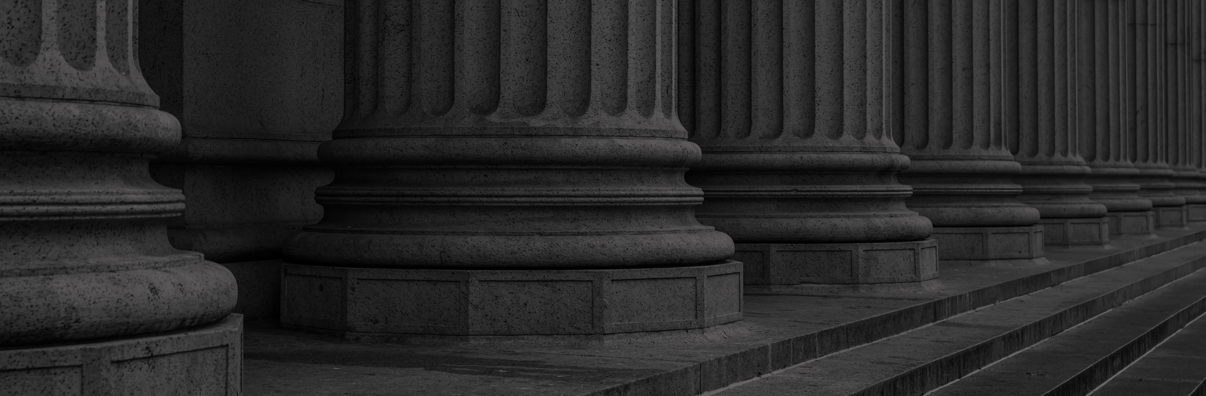 Row of classical stone columns on a dark background