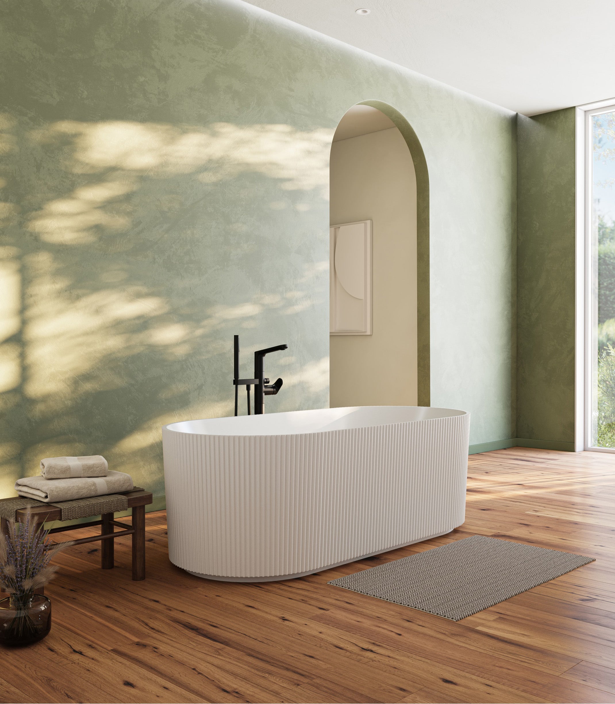 Modern bathroom with a freestanding bathtub, wooden floor, and green wall.