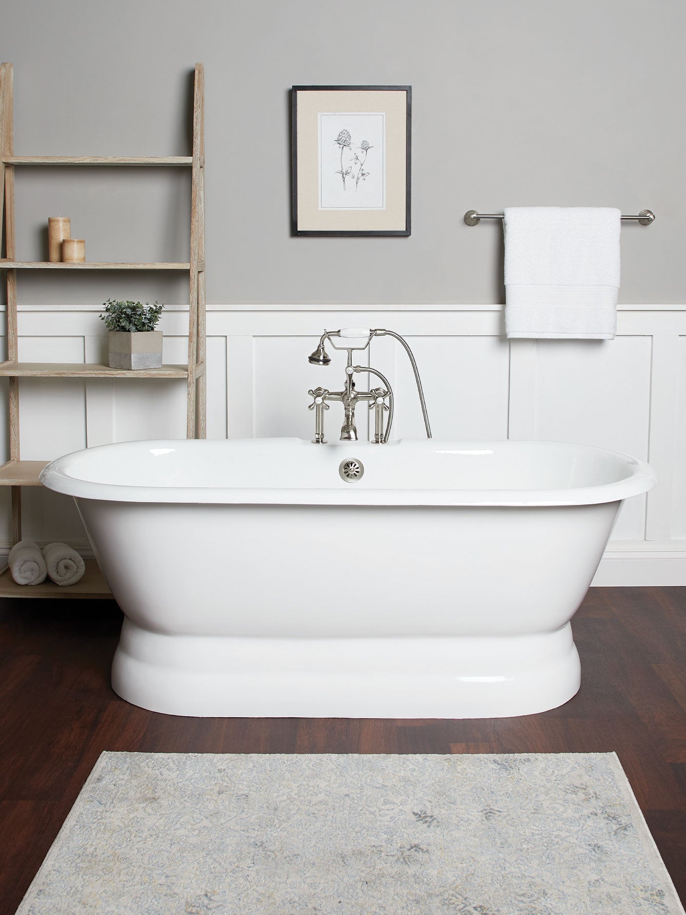 Bathroom with a freestanding bathtub, wooden shelf, and framed picture on a gray wall.