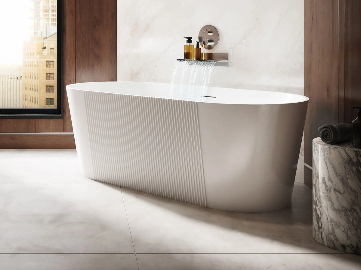 Modern freestanding bathtub in a bathroom with marble walls and floor.